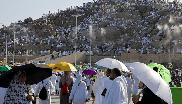 مسلمان حجاج کوہ عرفات پر چڑھتے ہیں، جسے جبل الرحمہ (رحم کا پہاڑ) بھی کہا جاتا ہے۔  - اے ایف پی
