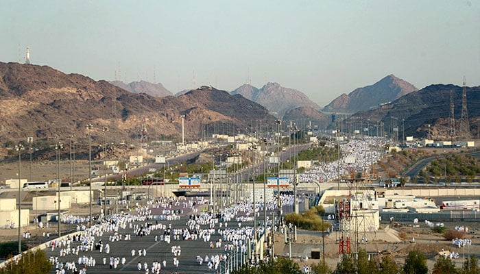 مسلمان حجاج کوہِ عرفات کی طرف چلتے ہیں، جسے جبل الرحمہ (رحم کا پہاڑ) بھی کہا جاتا ہے۔  - اے ایف پی