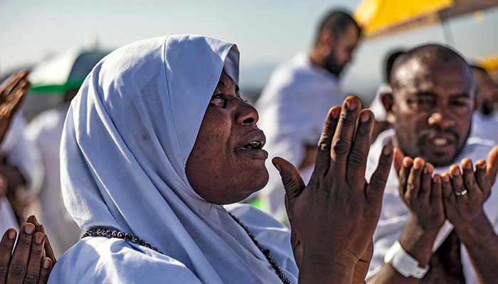ایک عورت عرفات کے پہاڑ پر نماز پڑھ رہی ہے، جسے جبل الرحمہ بھی کہا جاتا ہے، مکہ کے جنوب مشرق میں۔  - اے ایف پی