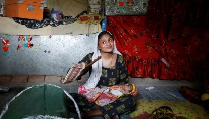 Farmer Waderi, 17, fans her one-month-old son Amar Kumar during a heatwave, at home, on the outskirts of Jacobabad, Pakistan, May 17, 2022.— Reuters