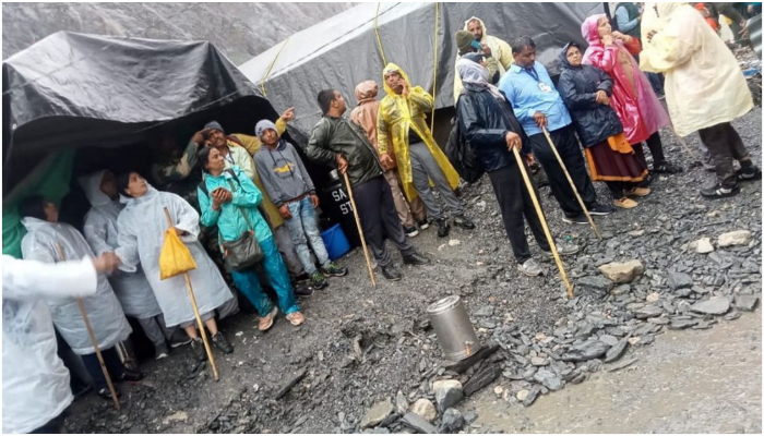 People stand outside tents after a cloudburst near the holy Amarnath cave shrine in IoJK July 8, 2022.—  National Disaster Response Force/Handout via Reuters