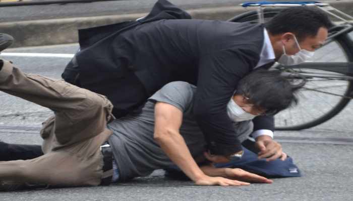 A man, believed to be a suspect shooting Japanese Prime Minister Shinzo Abe is held by police officers at Yamato Saidaiji Station in Nara, Photo— The Yomiuri Shimbun/KYODO via REUTERS