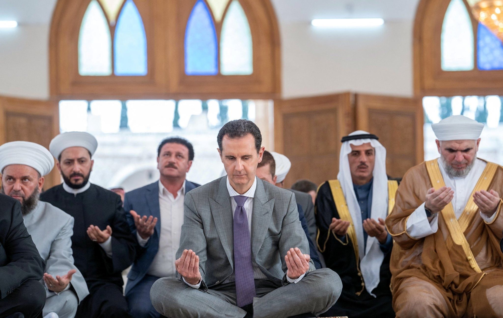 شام کے صدر بشار الاسد 9 جولائی 2022 کو SANA کی طرف سے جاری کردہ اس ہینڈ آؤٹ میں، شام کے شہر حلب میں صحابی عبداللہ بن عباس مسجد میں عید الاضحی کی نماز میں شرکت کر رہے ہیں۔