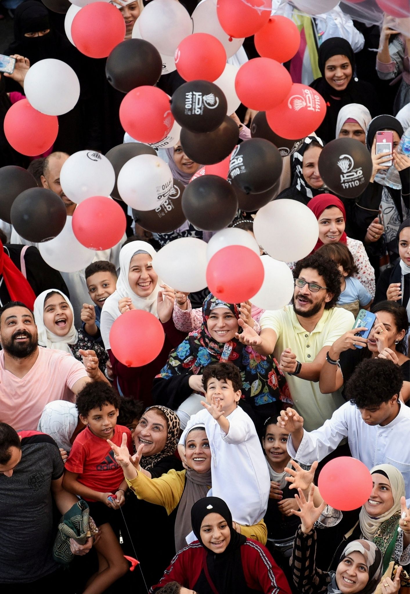 People attempt to catch balloons released after an Eid al-Adha prayer at a public park, outside El-Seddik Mosque in Cairo, Egypt, July 9, 2022.