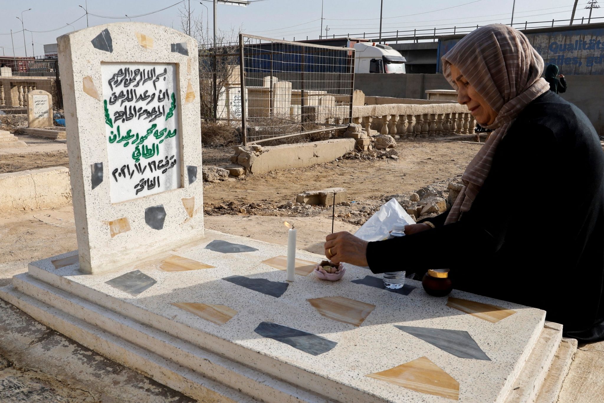 Seorang wanita mengunjungi makam kerabatnya di pemakaman pada hari pertama festival Muslim Idul Adha di Baghdad, Irak, 9 Juli 2022.