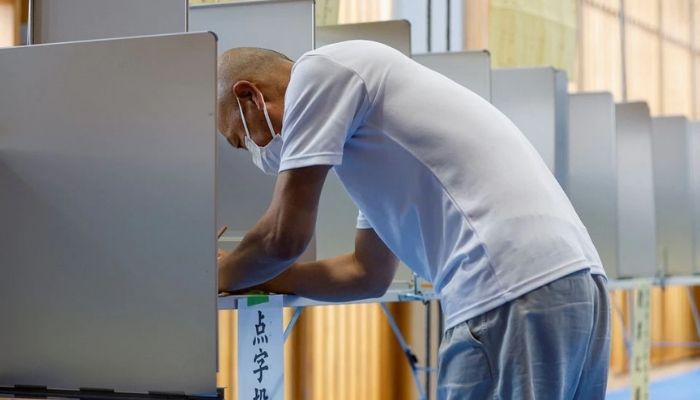 A voter prepares to cast his ballot in the upper house election at a polling station in Tokyo, Japan July 10, 2022. — Reuters