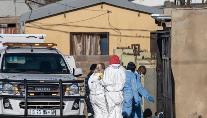 Members of the South African Police Service (SAPS) and forensic pathology service inspect the scene of a mass shooting in Soweto, South Africa, on July 10, 2022. Photo: AFP