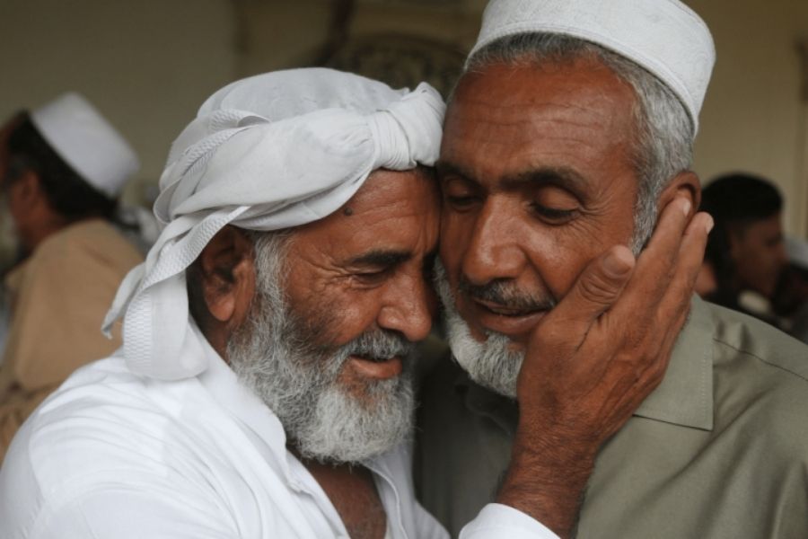 Afghan refugees embrace after Eidul Azha prayers at a mosque on the outskirts of Peshawar on Saturday. —AFP