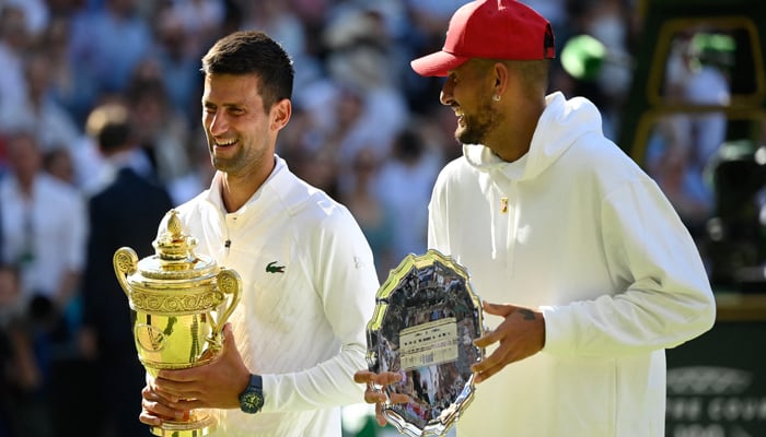 Serbias Novak Djokovic poses with the trophy after winning the mens singles final alongside runner up Australias Nick Kyrgios, at All England Lawn Tennis and Croquet Club, London, Britain, July 10, 2022. — Reuters/Toby Melville