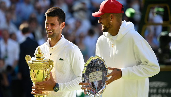 Serbias Novak Djokovic poses with the trophy after winning the mens singles final alongside runner up Australias Nick Kyrgios, at All England Lawn Tennis and Croquet Club, London, Britain, July 10, 2022. — Reuters/Toby Melville