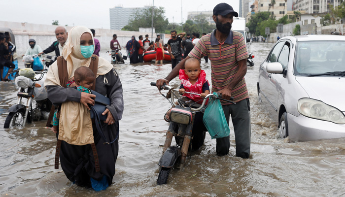A family wades through a flooded road during the monsoon season in Karachi, Pakistan July 9, 2022. —Reuters