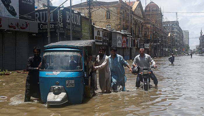 Residents commute through a flooded street during the monsoon season, in Karachi, Pakistan July 11, 2022. — Reuters