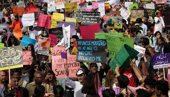 Women and men carry signs as they take part in an Aurat March, or Womens March in Lahore, Pakistan March 8, 2020. — Reuters