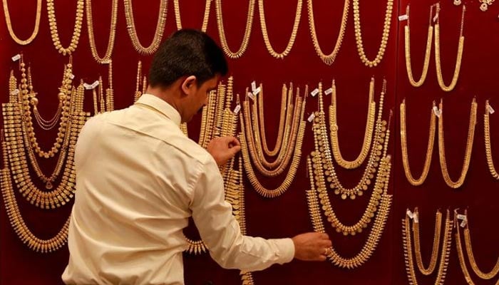 A salesman arranges gold ornaments, on a display board, inside a jewellery showroom during Akshaya Tritiya, a major gold-buying festival, in Kochi, India April 28, 2017. — Reuters/File