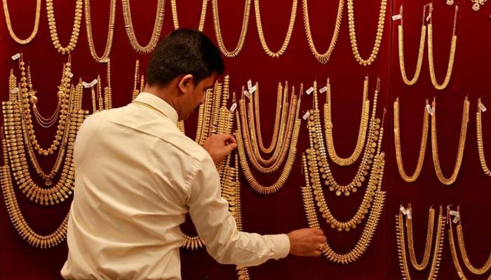 A salesman arranges gold ornaments, on a display board, inside a jewellery showroom during Akshaya Tritiya, a major gold-buying festival, in Kochi, India April 28, 2017. — Reuters/File