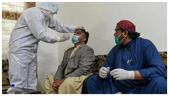 A paramedic takes a testing sample from a man during an earlier nationwide lockdown over the COVID-19 pandemic in Pakistan.— AFP/File