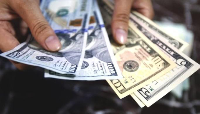 A representational image of a man holding dollar bills. — AFP
