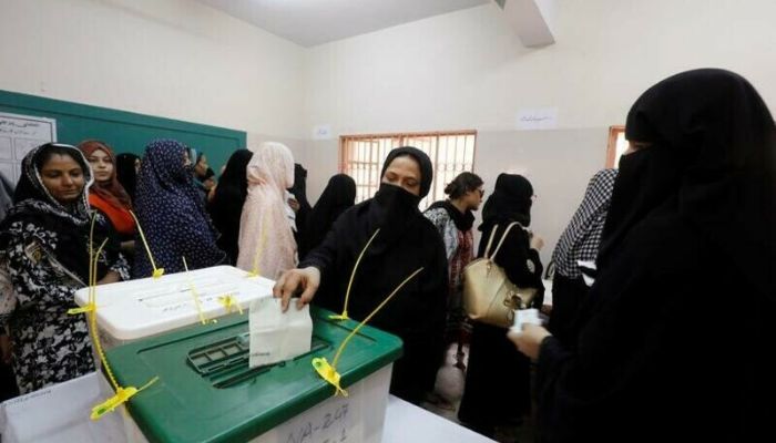 A woman casts her ballot while other wait for their turn at a polling station during the general election in Karachi, Pakistan, July 25, 2018 - Reuters
