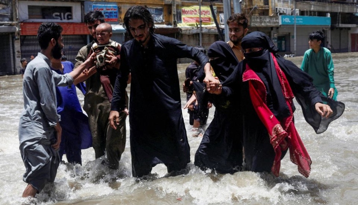 A family wades through a flooded street during the monsoon season, in Karachi, Pakistan July 11, 2022. — Reuters/File