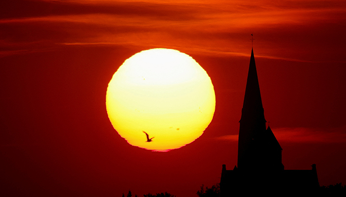 A church is pictured during sunset as a heat wave hits Europe, in Oisy-le-Verger, France, July 14, 2022. — Reuters