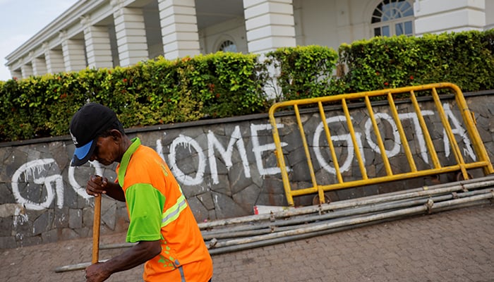 A man sweeps the road to Presidents official residence after parliament Speaker Mahinda Yapa Abeywardena officially announced the resignation of president Gotabaya Rajapaksa who fled to Singapore amid Sri Lankas economic crisis, in Colombo, Sri Lanka, July 15, 2022. — Reuters