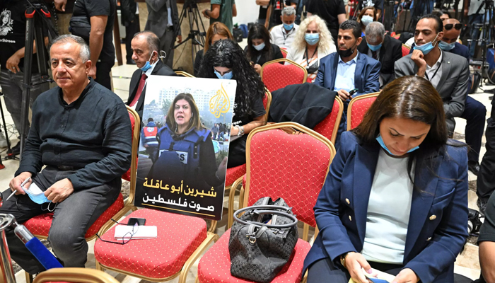 A photo of slain US-Palestinian Al Jazeera correspondent Shireen Abu Akleh, with a caption in Arabic calling her the voice of Palestine, is seen amongst reporters ahead of a joint press conference between the US and Palestinian presidents. — AFP