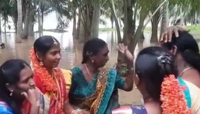 Pengantin wanita mencapai rumah pengantin pria dengan perahu saat hujan deras