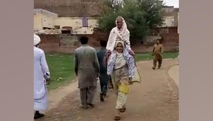 A daughter can be seen carrying her mother to cast vote on July 17, 2022. — Twitter