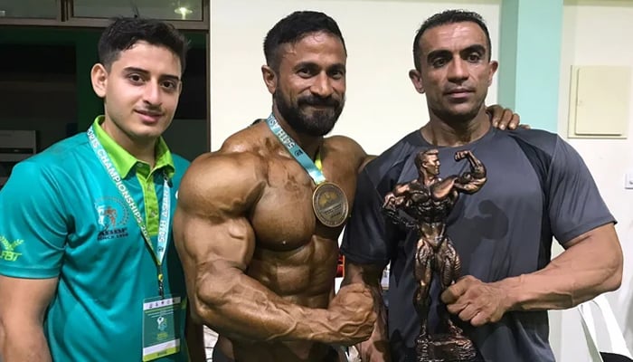 Shahzad Qureshi (C) posing with his gold medal and trophy along with his colleague Fazal Ilahi (R). — Geo Super