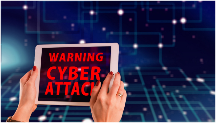 Representational image of a woman holding a tablet, while its screen says warning, cyber attack. — Pixabay/ Gerd Altmann