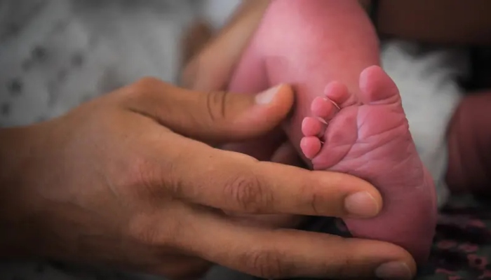 Representational image showing a person holding a babys feet. — AFP/File