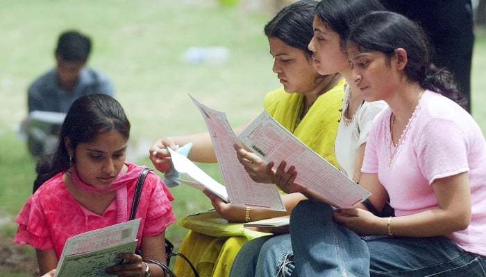 Representational image of college girls looking at their result sheets. — AFP/File