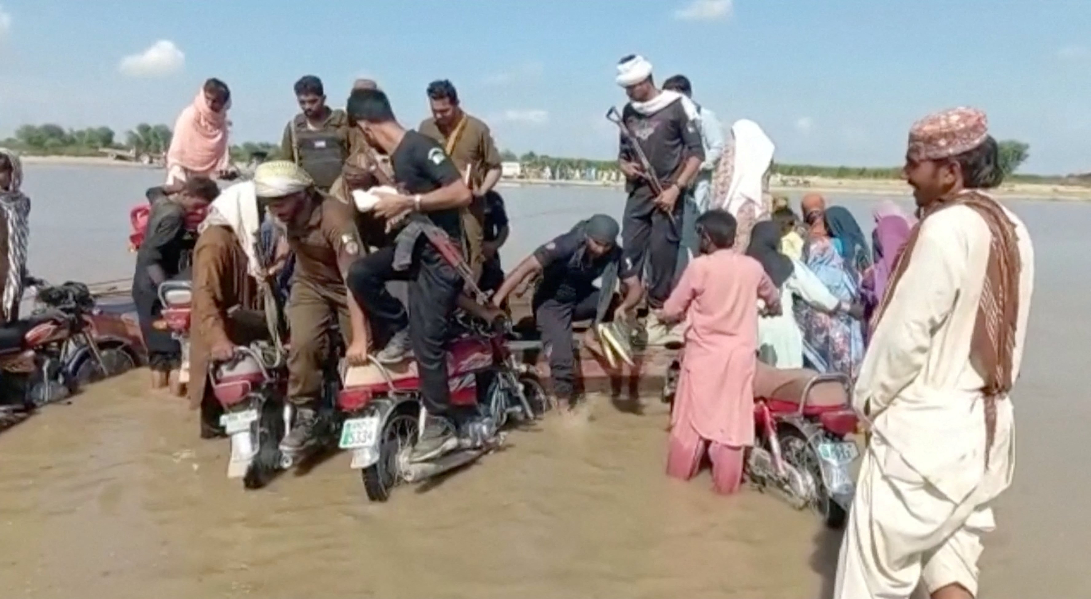 Rescuers and locals help survivors, after a boat carrying around 100 people capsized in a central Pakistani river, in Sadiqabad, Pakistan, July 18, 2022, in this still image taken from a handout video. — Punjab Government/Handout via REUTERS