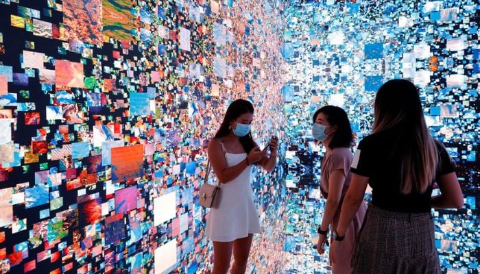 Visitors are pictured in front of an immersive art installation titled Machine Hallucinations — Space: Metaverse by media artist Refik Anadol, which will be converted into NFT and auctioned online at Sothebys, at the Digital Art Fair, in Hong Kong, China September 30, 2021.— Reuters