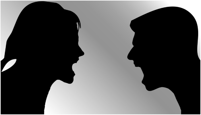 Silhouettes of a man and a woman shouting at each other. — Pixabay