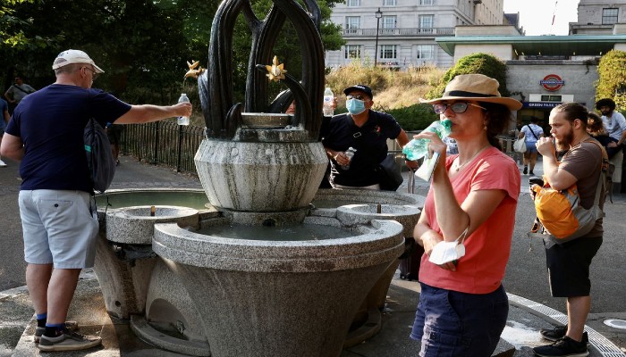 People collect water from a fountain in Green Park in London, Britain. July 18, 2022. —REUTERS/Kevin Coombs