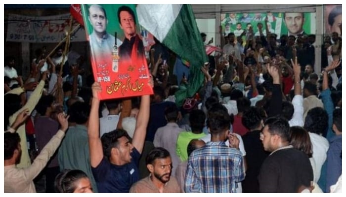 PTI workers dance with jubiliation as they win a crucial election in PP 158 Lahore. — APP