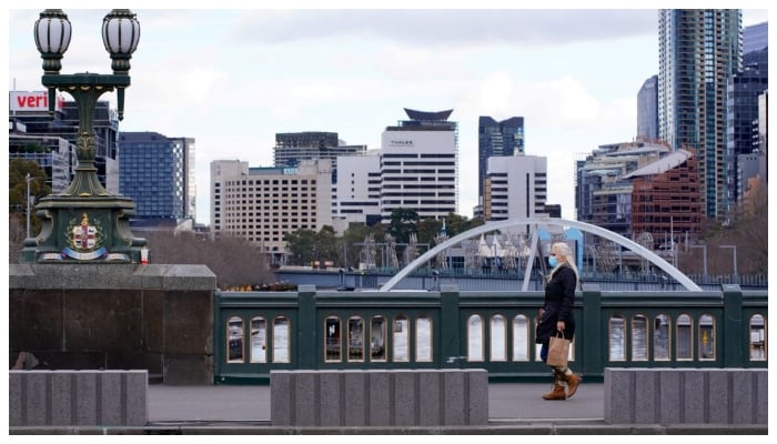 A lone woman, wearing a protective face mask, walks across a city centre bridge as the state of Victoria looks to curb the spread of a COVID-19 outbreak in Melbourne, Australia, July 16, 2021. — Reuters