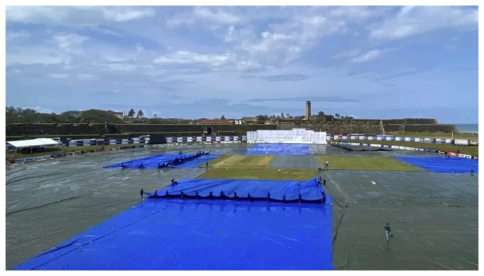 Stadium staff covers field to save it from being soaked in rain. — Courtesy cricinfo