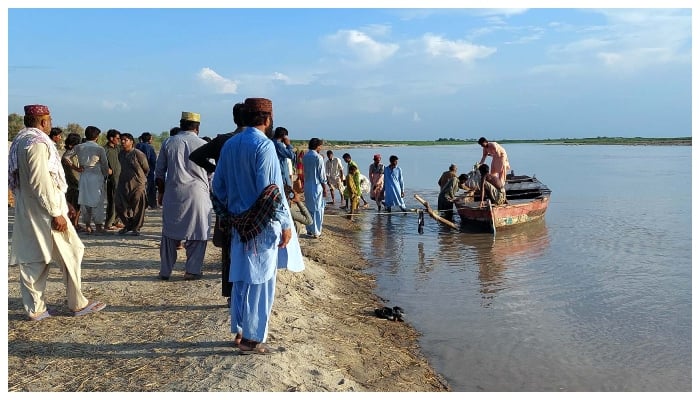 People gathered at the bank of Indus River after the boat capsizing incident. — PPI