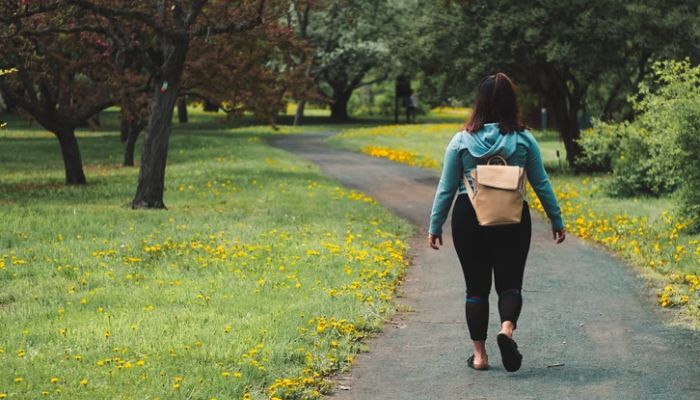 Woman walking in a park. — Unsplash