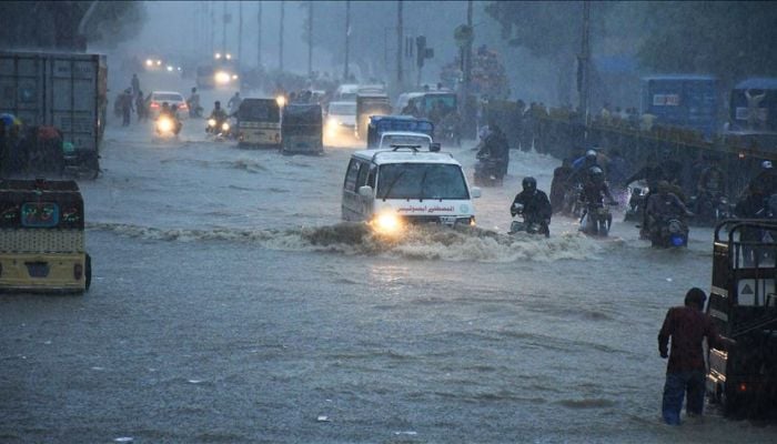 Commuters struggle to move forward in a flooded street after heavy monsoon rains in Pakistans port city of Karachi on August 27, 2020.  — Anadolu Agency