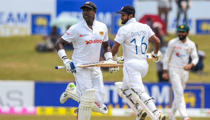 Sri Lanka’s captain Dimuth Karunaratne (R) and Angelo Mathews (L) run between the wickets during the first day of the second cricket Test match between Sri Lanka and Pakistan. Photo: AFP