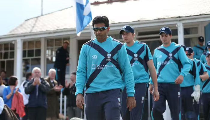 Majid Haq (left) of Scotland walks from the pavillion during an ODI match between Scotland and England at Mannofield, Aberdeen, northeast Scotland on May 9, 2014. Photo: AFP