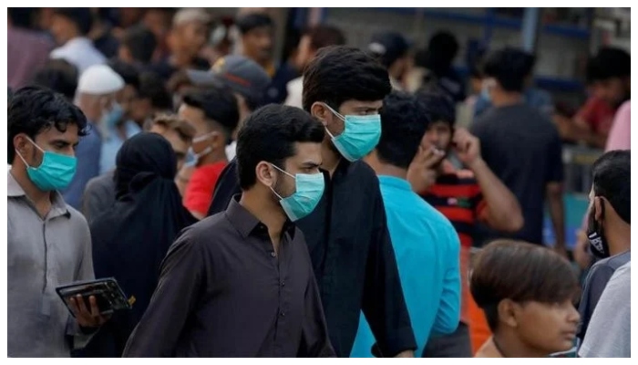 Men wearing protective face masks walk amid the rush of people outside a market during an outbreak of the coronavirus disease (COVID-19) continues, in Karachi, Pakistan June 8, 2020. — Reuters/File