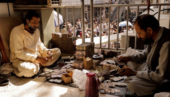 Afghan currency exchange workers count money at a market in Kabul, Afghanistan October 7, 2021. — Reuters