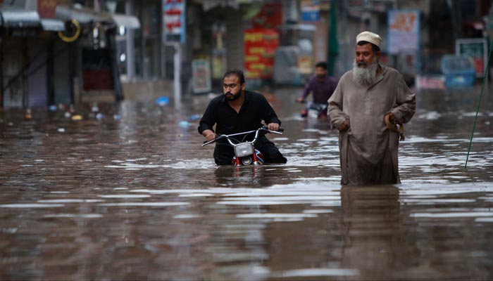 Motorcyclist struggles to pass through accumulated rainwater after heavy rain in Rawalpindi. — APP/File