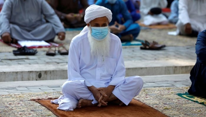 A man wears protective mask maintaining social distance with others as they gather to celebrate Eid al-Fitr prayers to mark the end of the holy fasting month of Ramadan, as the outbreak of the coronavirus disease (COVID-19) continues in Peshawar, Pakistan May 13, 2021. — Reuters/File