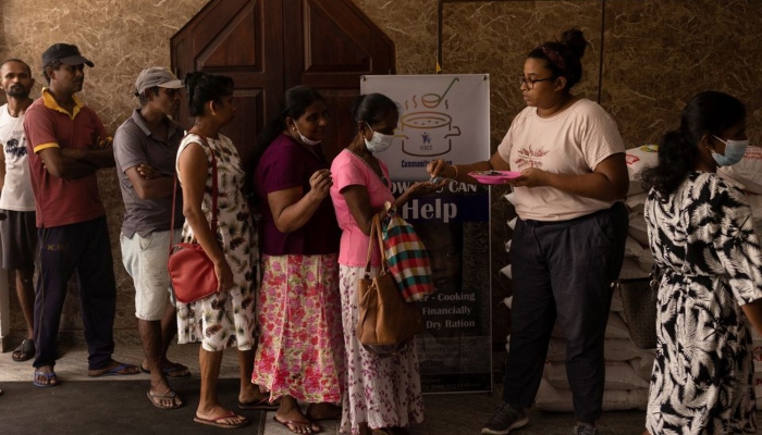Aru de Silva, 36, a volunteer, distributes tokens for free food inside a community kitchen at a church, amid the countrys economic crisis, in Colombo, Sri Lanka, July 25, 2022. — Reuters