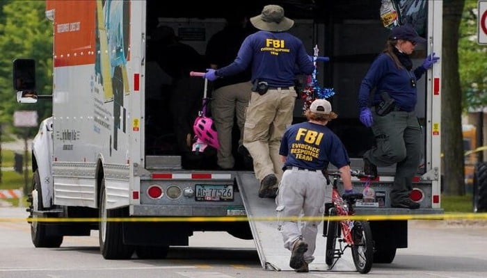 FBI agents clear abandoned belongings from the scene after a mass shooting at a Fourth of July parade in the Chicago suburb of Highland Park, Illinois, U.S., July 7, 2022. — REUTERS/Cheney Orr